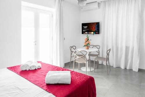 a bedroom with a table and a bed with a red blanket at Case vacanza Partenope in Agropoli