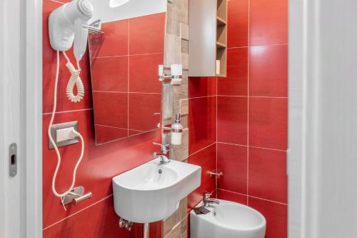 a red bathroom with a sink and a toilet at Case vacanza Partenope in Agropoli