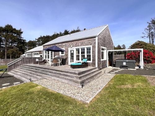 a house with a wooden deck with a grill at Sunset Beach Getaway in Moclips