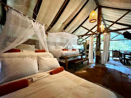 a bedroom with two beds with mosquito netting at Ecocabaña Pocahontas en rio Santo Domingo, Melcocho in Cocorná