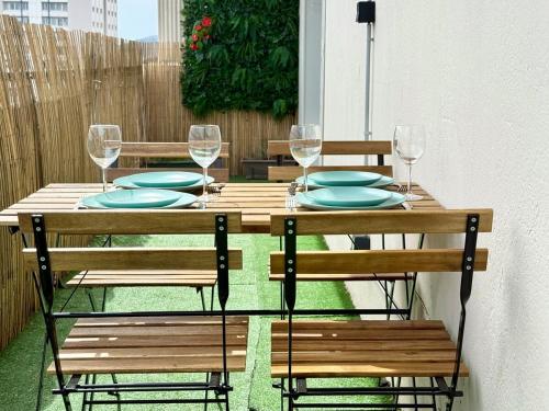une table en bois avec des assiettes et des verres à vin dessus dans l'établissement Spacieux - Terrasse - Vue Mer & Rade, à Toulon