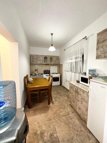 a kitchen with a wooden table and a dining room at Apartman Cesare in Tivat