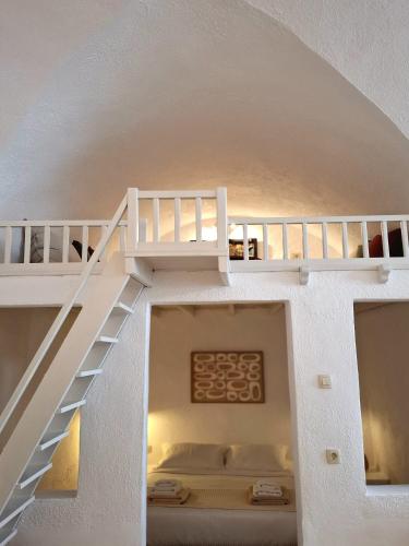 an attic room with stairs in a house at Mardanza Krokos Suites in Imerovigli