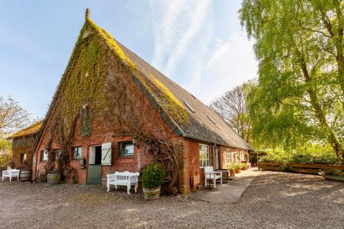 a building with a roof covered in moss at Hof Fetthörn, Ferienzimmer Muschel in Giekau