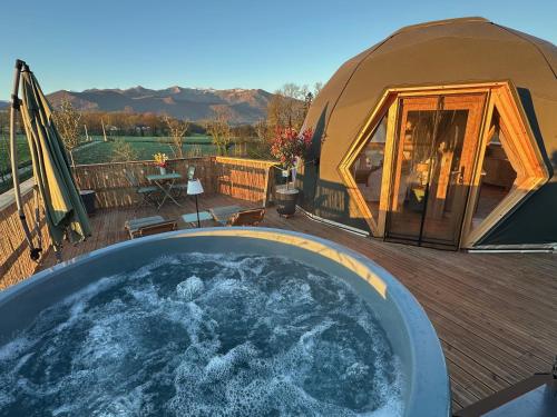 a yurt with a hot tub on a deck at L'étoile du Béarn in Asson