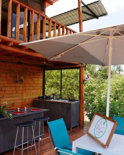 a patio with a table and chairs and an umbrella at Cabaña con vistas a la montaña in Cachipay