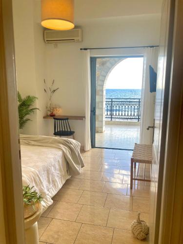 a bedroom with a bed and a view of the ocean at Selini Apartments Mani in Agios Nikolaos