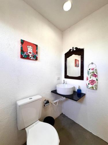 a bathroom with a white toilet and a sink at Suíte 8 - Village Capixaba in Gravatá
