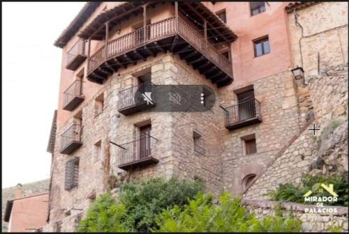 a building with a sign on the side of it at Mirador de Palacios- céntrico con vistas y parking cerca in Albarracín