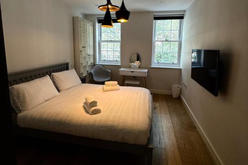 a bedroom with a bed with two towels on it at Covent Garden 2-Bed Apt Sleeps 6 4 Mins to Tube in London