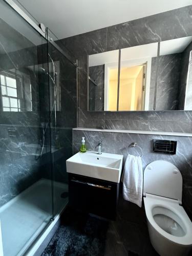a bathroom with a sink and a toilet and a shower at Covent Garden 2-Bed Apt Sleeps 6 4 Mins to Tube in London