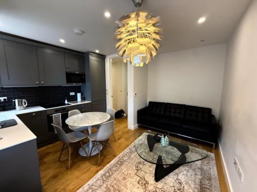 a kitchen and living room with a table and a couch at Covent Garden 2-Bed Apt Sleeps 6 4 Mins to Tube in London
