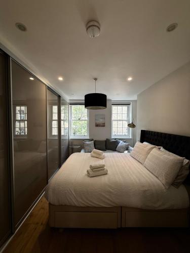 a bedroom with a large bed with towels on it at Covent Garden 2-Bed Apt Sleeps 6 4 Mins to Tube in London