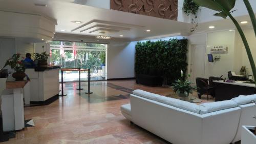 a lobby with a white couch and plants in it at Lancaster House in Bogotá