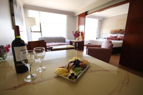 a bottle of wine and a plate of food on a table at Lancaster House in Bogotá