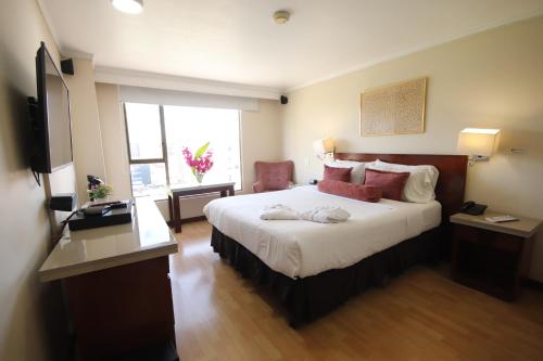 a hotel room with a large bed and a window at Lancaster House in Bogotá