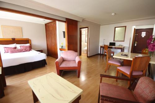 a hotel room with a bed and a living room at Lancaster House in Bogotá