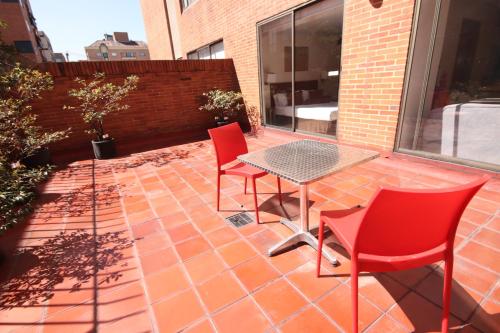 a patio with a table and chairs on a brick patio at Lancaster House in Bogotá