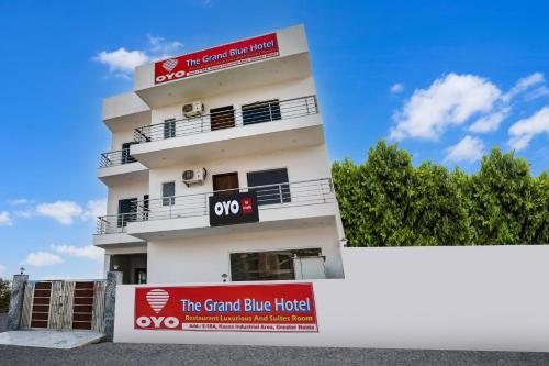 un edificio bianco con un cartello davanti di Hotel O The Grand Blue Hotel a Noida