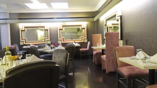 a dining room with tables and chairs and a mirror at Lancaster House in Bogotá