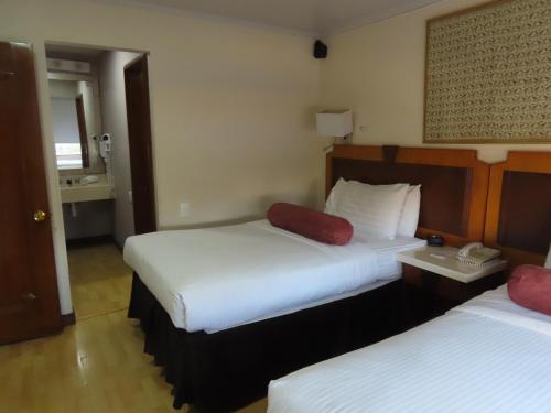 a hotel room with two beds and a telephone at Lancaster House in Bogotá