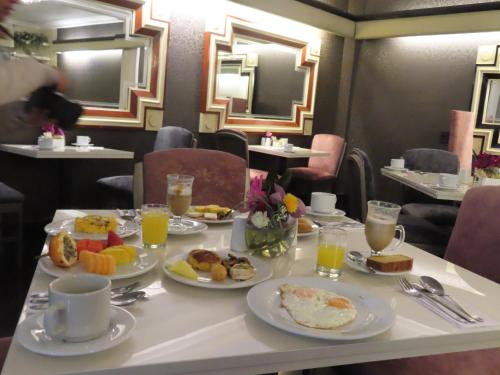 a table with plates of breakfast food on it at Lancaster House in Bogotá