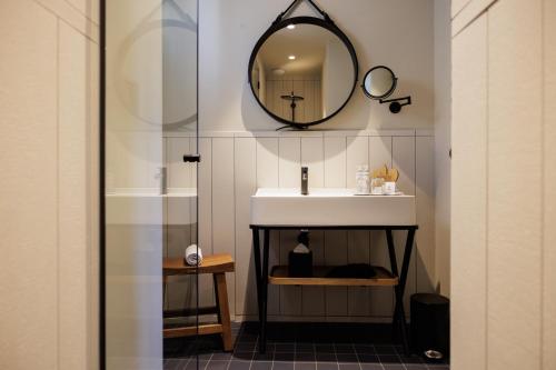 a bathroom with a sink and a mirror on the wall at Domaine de Locguénolé & Spa - Relais & Chateaux in Kervignac