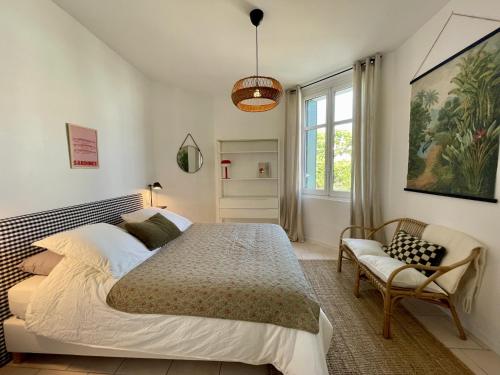 een slaapkamer met een groot bed en een stoel bij Villa Georgette in Saint-Gilles-Croix-de-Vie