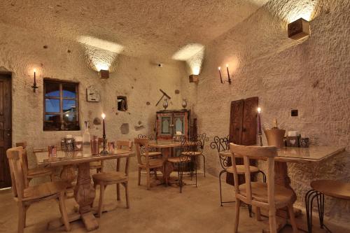 a restaurant with tables and chairs in a room at The Owl Cave Hotel in Göreme