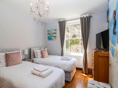 a bedroom with two beds and a window at Albany in Looe