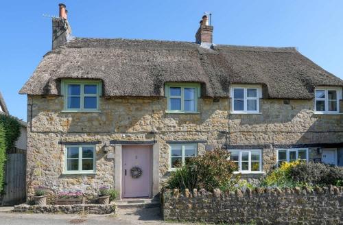 an old stone cottage with a thatched roof at 18th Century Thatched Cottage Parking & Garden in Beaminster