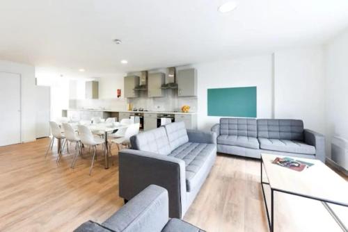 a living room with couches and a table and a kitchen at Student Only - Pittrodrie Street Aberdeen in Aberdeen