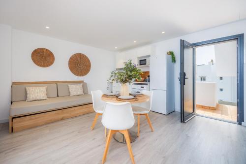 a living room with a table and white chairs at White suites in Cala d´Or