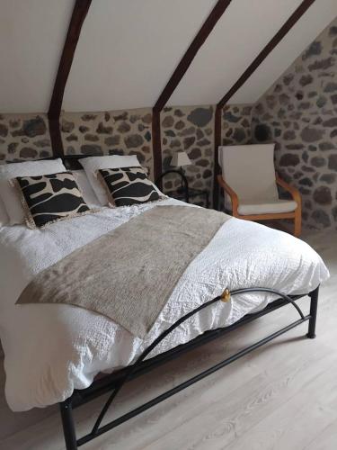 un lit dans une chambre avec un mur en pierre dans l'établissement ferme de Lamourio, à Saint-Cernin