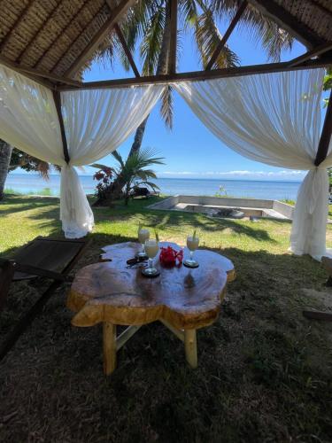 a table under a tent with a view of the beach at La Spiaggia, tropical villa with private beach in Sainte Marie