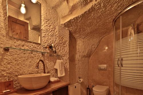ギョレメにあるThe Owl Cave Hotelの石造りのバスルーム(洗面台、トイレ付)