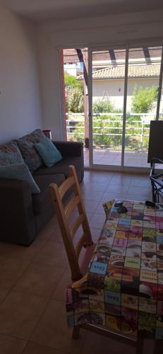 - un salon avec un canapé, une chaise et une table dans l'établissement jolie appartement pour 4 personnes à propriano, à Propriano