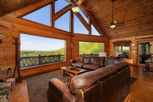 a living room with a leather couch and large windows at Majestic View in Mashburn Mill