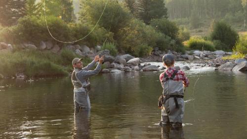two people are standing in the water fishing at Montaneros in Vail in Vail