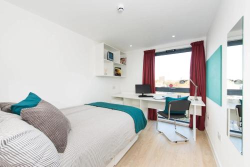 a bedroom with a bed and a desk with a computer at For Students Only Vincent Place in Southampton in Southampton