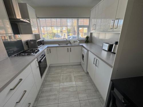 a kitchen with white cabinets and a stove top oven at Modern 3-Bed Family Home in Quiet Sheffield Area in Wincobank