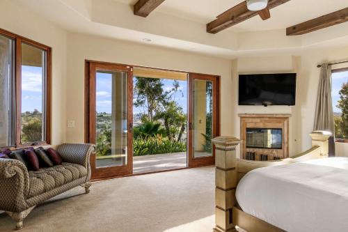 Un dormitorio con una cama, una chimenea y un televisor. en 7BR Carlsbad Estate with Pool Firepit & Views, en Carlsbad