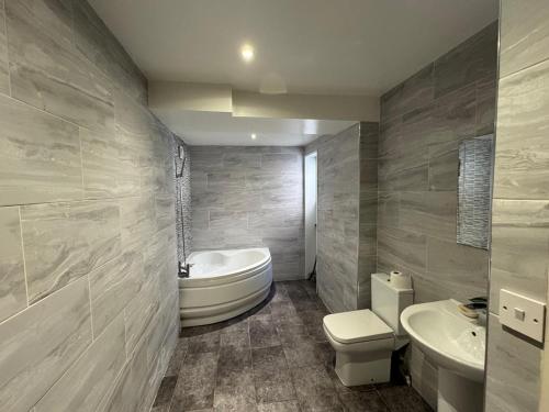 ein Badezimmer mit Badewanne, Toilette und Waschbecken in der Unterkunft Modern 3-Bed Family Home in Quiet Sheffield Area in Wincobank