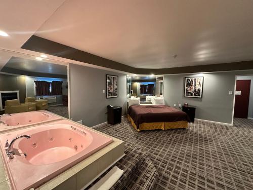 a hotel room with a large tub and a bed at Inn of the Dove - Romantic Luxury Suites with Jacuzzi & Seasonal Fireplace at Harrisburg-Hershey-Philadelphia, PA in Harrisburg