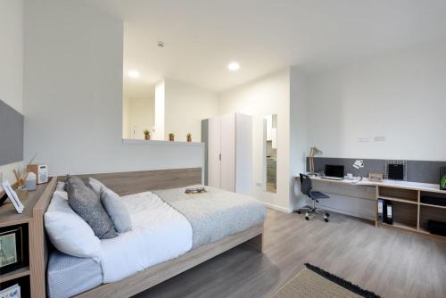 a bedroom with a bed and a desk with a computer at For Students Only St Mungo's in Glasgow in Glasgow
