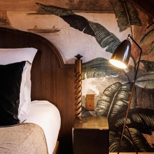 a bedroom with a bed and a lamp on a table at Domaine de Locguénolé & Spa - Relais & Chateaux in Kervignac
