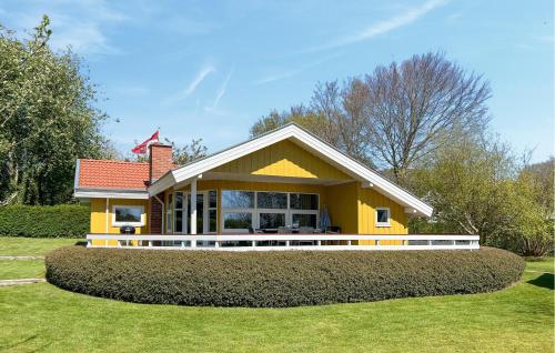 a small yellow house with a large yard at Holiday Home Slåenvænget Hejls Xii in Hejls