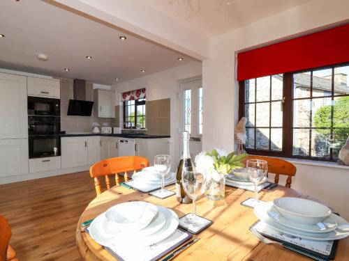 Una cocina y un comedor con mesa y sillas de madera. en Kernyk, en Camelford