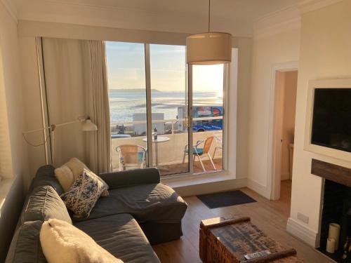 a living room with a couch and a large window at Flat 7 Sand Acres in Poole