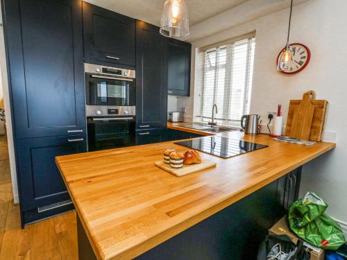a kitchen with black cabinets and a wooden counter top at Flat 7 Sand Acres in Poole